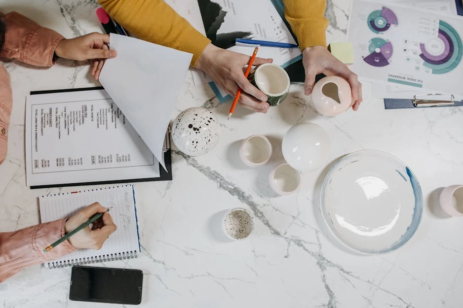 Una persona che scrive su un quaderno con un laptop e grafici futuristici sullo sfondo